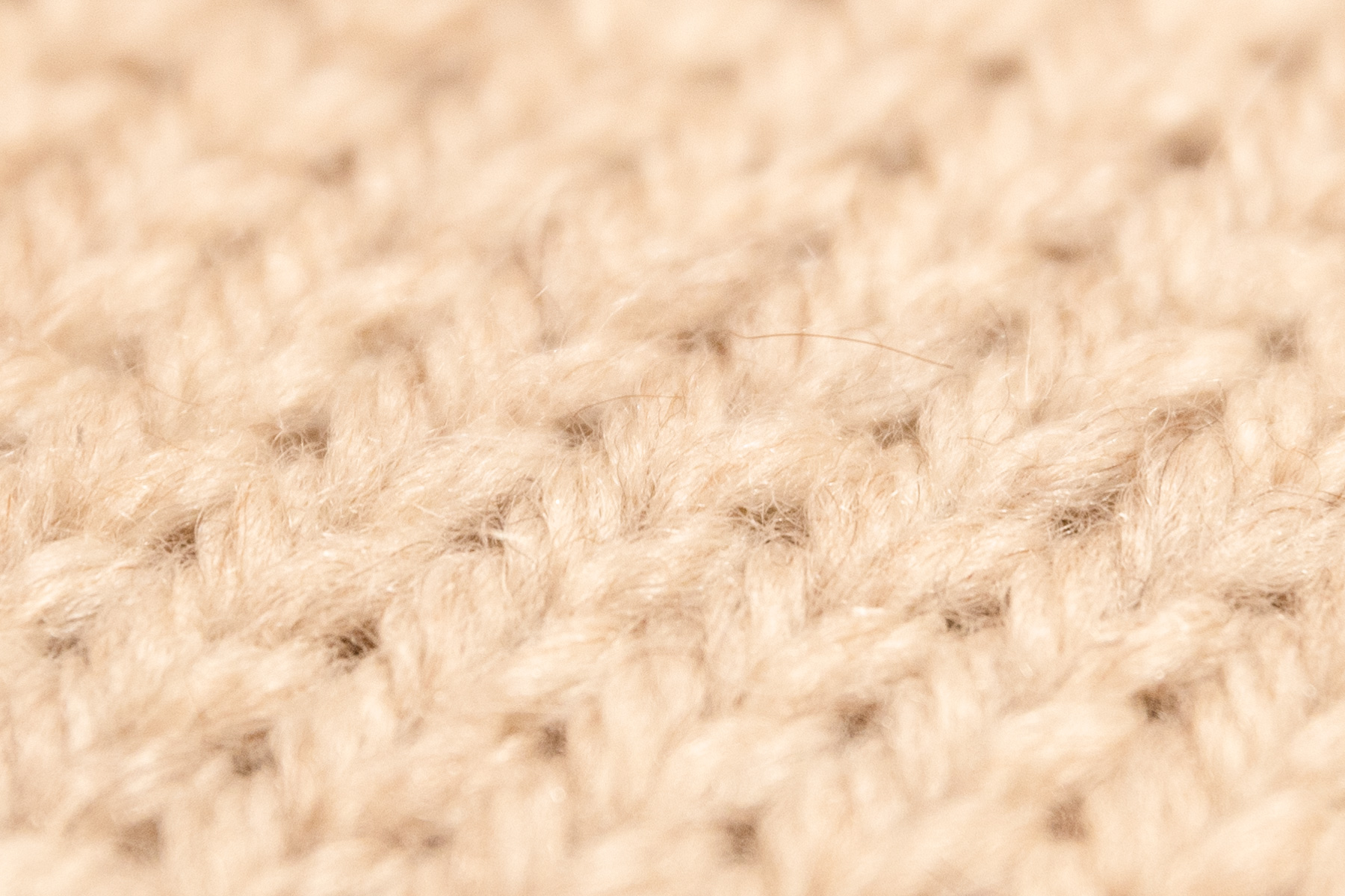 Close-up of Natural Alpaca knitting fabric. The brown furs are evenly mixed in the beige color.