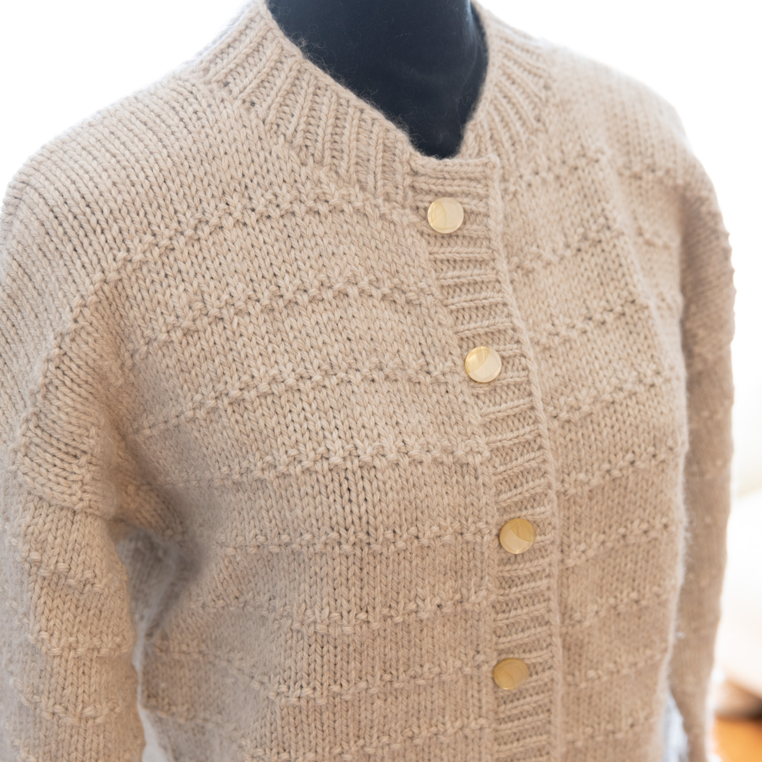 Cardigan knitted in Natural Alpaca. Diagonal side view.